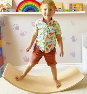 wooden balance board to help meet play milestones in early childhood